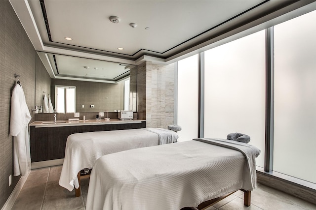 bedroom featuring crown molding, a raised ceiling, and sink