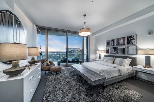 bedroom with dark colored carpet, access to outside, and floor to ceiling windows