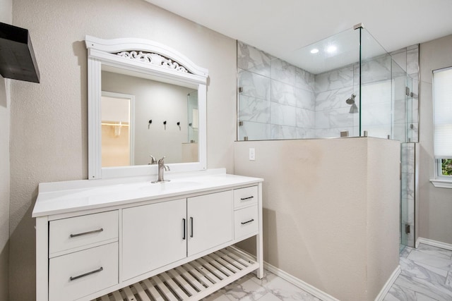 bathroom with a tile shower and vanity