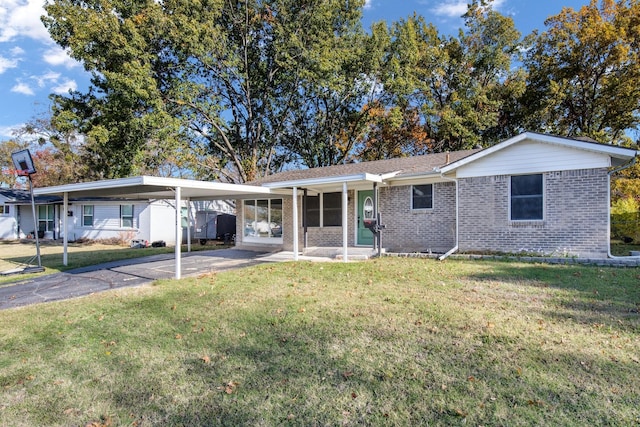 rear view of property featuring a carport and a yard