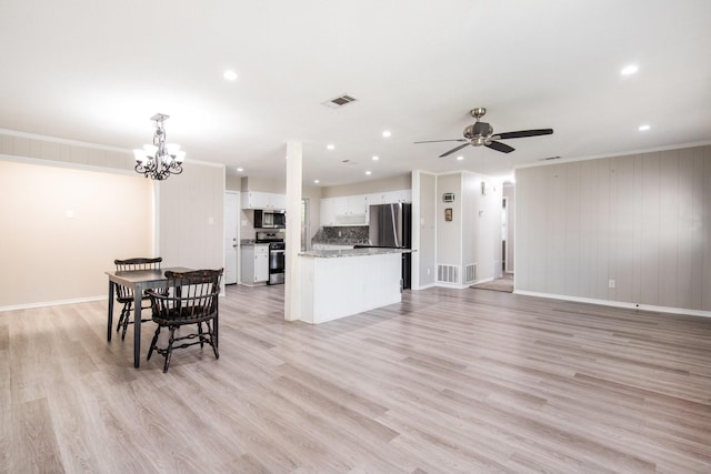 kitchen with light stone counters, light hardwood / wood-style flooring, pendant lighting, stainless steel appliances, and white cabinets