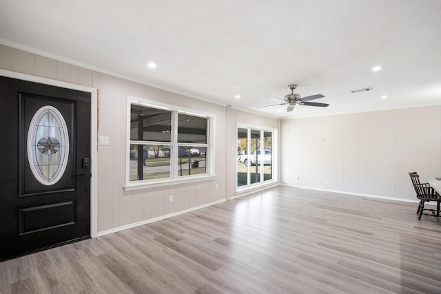 foyer entrance featuring crown molding, ceiling fan, and light wood-type flooring