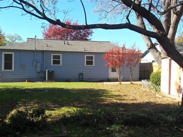 rear view of property with a yard and cooling unit