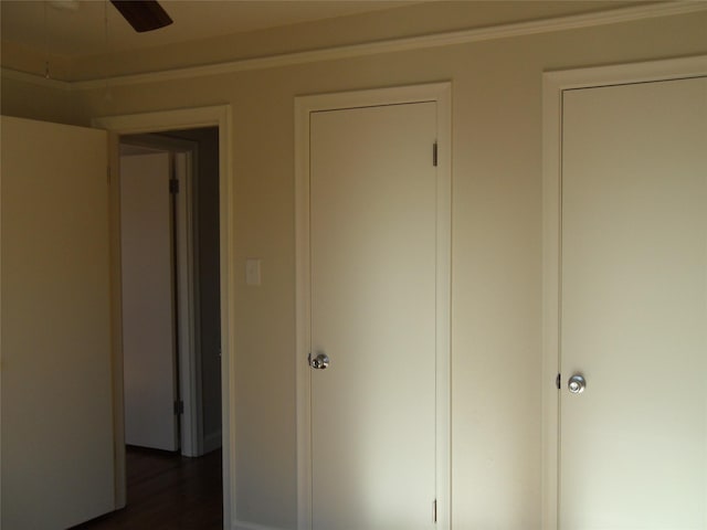 unfurnished bedroom featuring dark wood-type flooring and ceiling fan