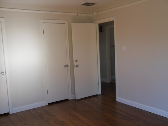 unfurnished bedroom with dark wood-type flooring and a closet