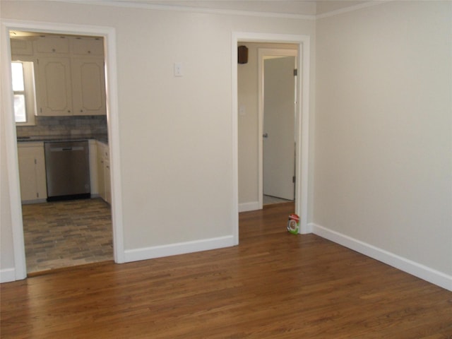 spare room featuring crown molding and dark hardwood / wood-style flooring