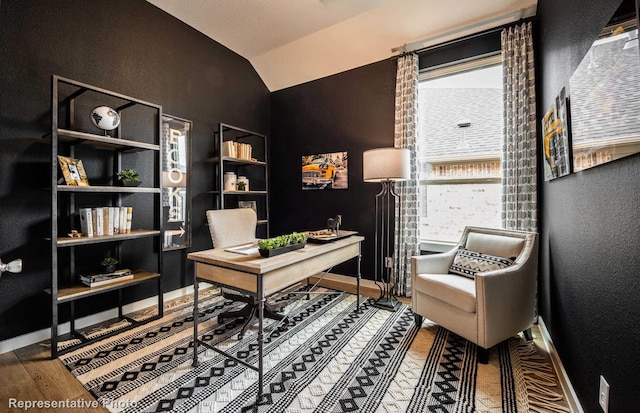 office with a textured wall, baseboards, lofted ceiling, and wood finished floors