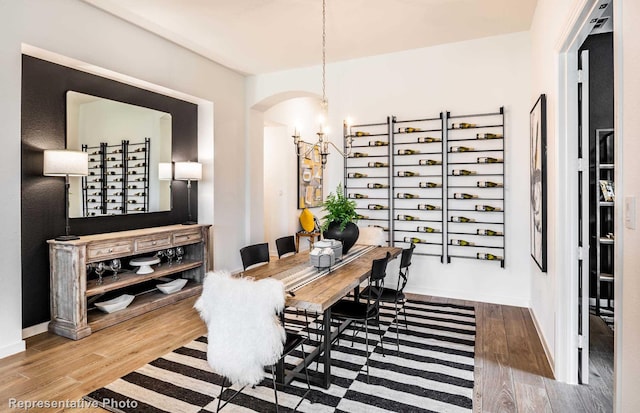 dining space featuring wood finished floors, baseboards, and a chandelier