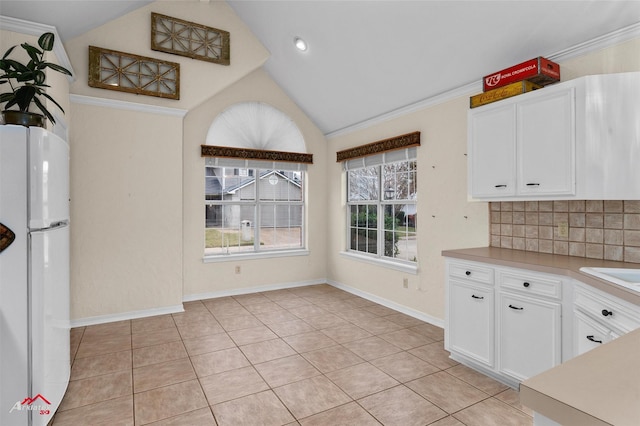 kitchen featuring white cabinets, white fridge, and crown molding