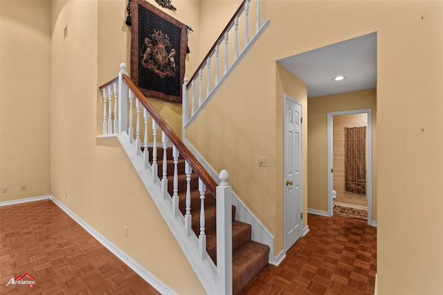 stairway featuring parquet floors