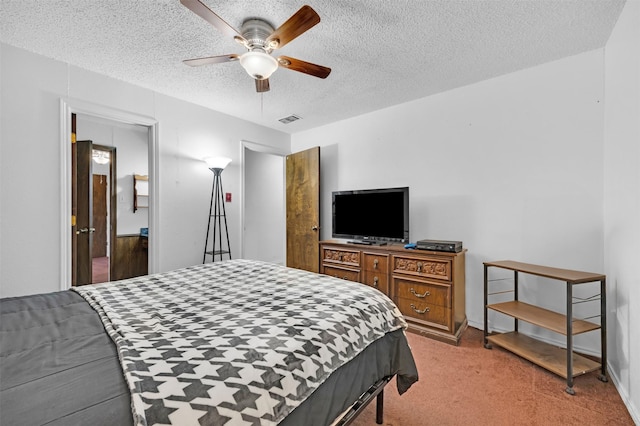 carpeted bedroom featuring ceiling fan and a textured ceiling