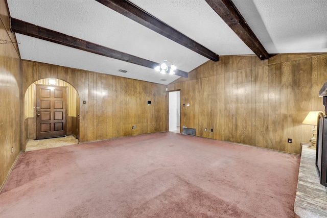 unfurnished living room featuring wood walls and light carpet