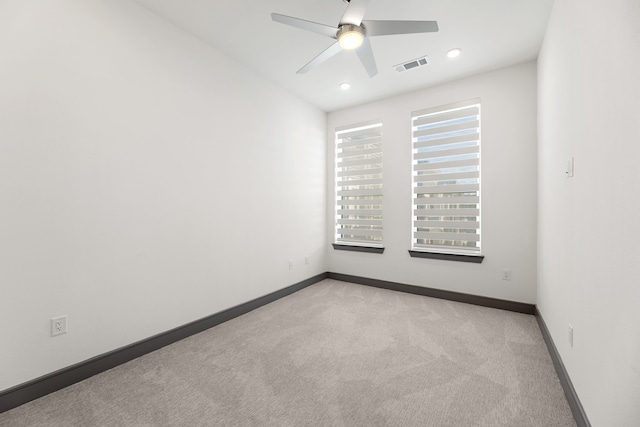 spare room featuring light colored carpet and ceiling fan