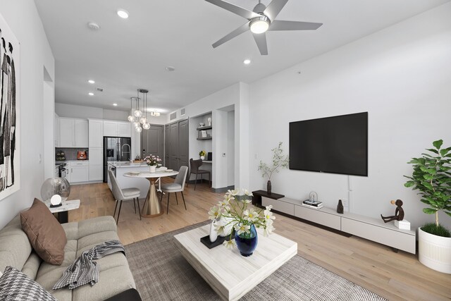 living room featuring ceiling fan and light hardwood / wood-style floors