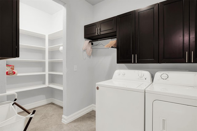 washroom with cabinets, light tile patterned floors, and washer and dryer