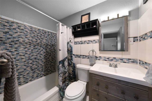 full bathroom with vanity, toilet, a textured ceiling, tile walls, and shower / tub combo with curtain