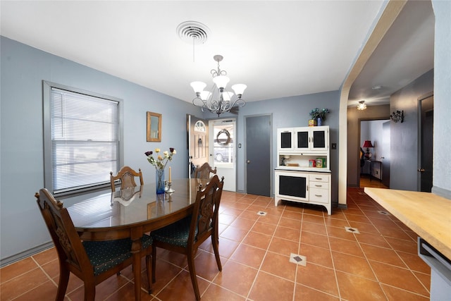 tiled dining space featuring a chandelier