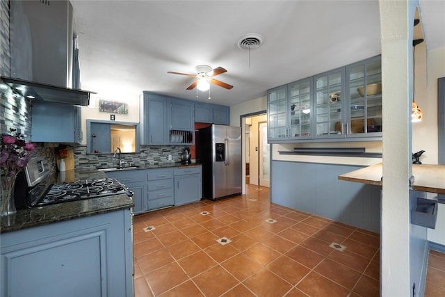 kitchen with blue cabinetry, sink, stainless steel appliances, ventilation hood, and decorative backsplash