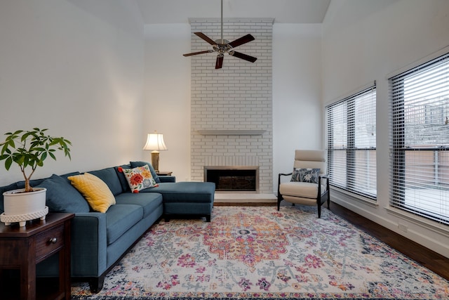 living room featuring hardwood / wood-style flooring, ceiling fan, lofted ceiling, and a fireplace