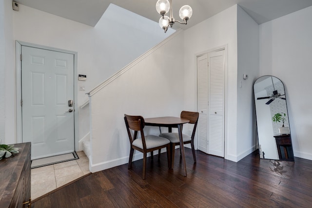 dining area with ceiling fan with notable chandelier and dark wood-type flooring