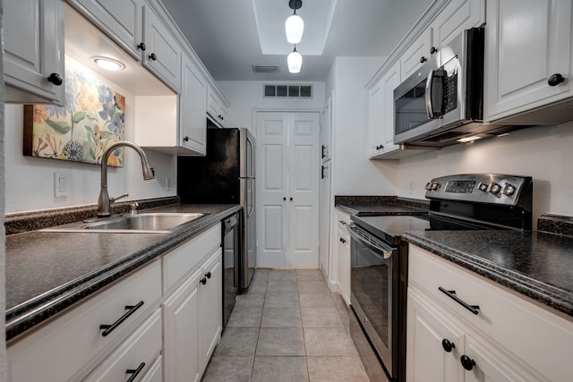 kitchen with light tile patterned floors, white cabinetry, sink, and appliances with stainless steel finishes