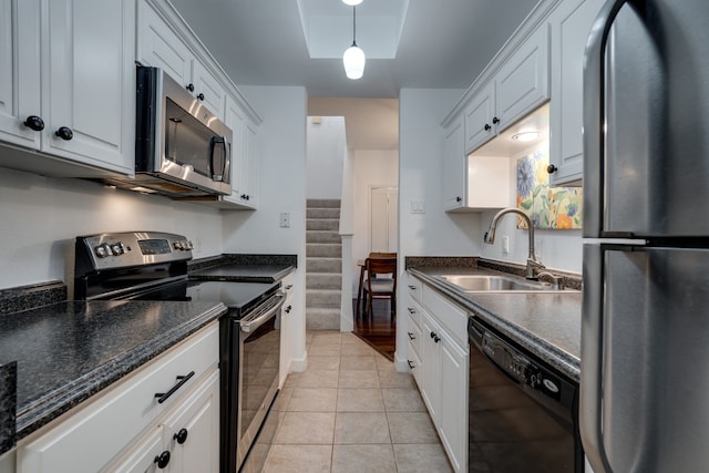 kitchen featuring sink, light tile patterned floors, pendant lighting, white cabinets, and appliances with stainless steel finishes