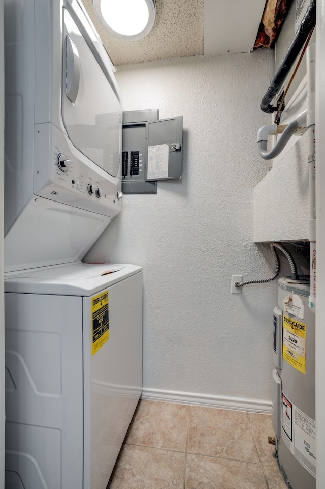 washroom featuring electric water heater, stacked washer and clothes dryer, and light tile patterned flooring