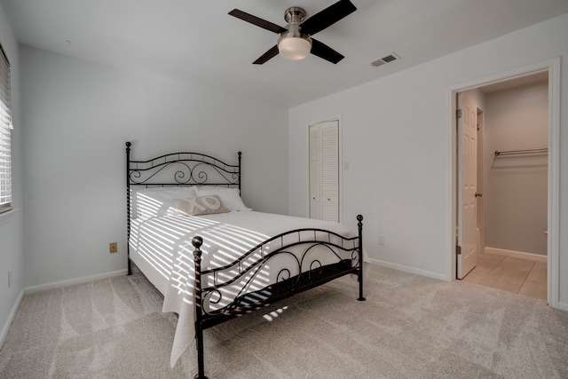 bedroom with ceiling fan, a closet, and light colored carpet