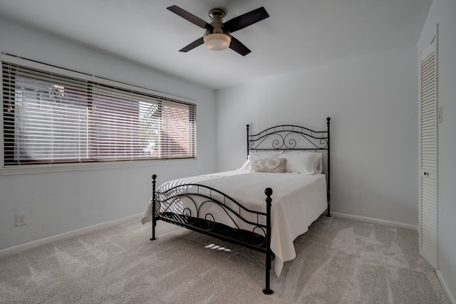 carpeted bedroom featuring ceiling fan and a closet