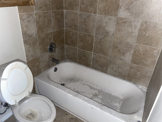 bathroom with tiled shower / bath combo and toilet