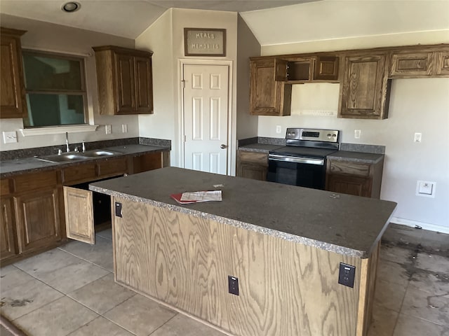 kitchen with electric stove, sink, vaulted ceiling, light tile patterned floors, and a kitchen island