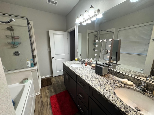 bathroom with hardwood / wood-style flooring, vanity, and shower with separate bathtub