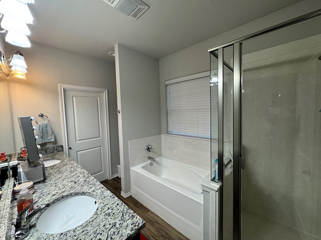 bathroom with shower with separate bathtub, vanity, and hardwood / wood-style flooring