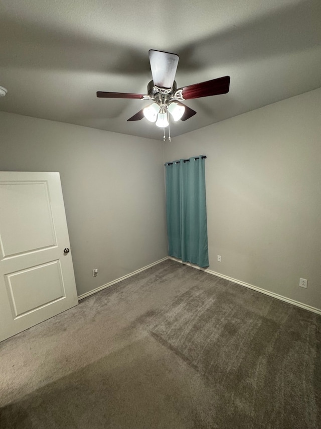 unfurnished room featuring ceiling fan and dark carpet