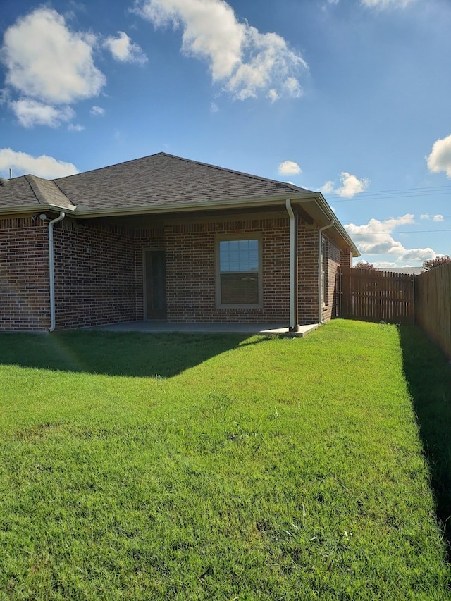 rear view of property featuring a lawn