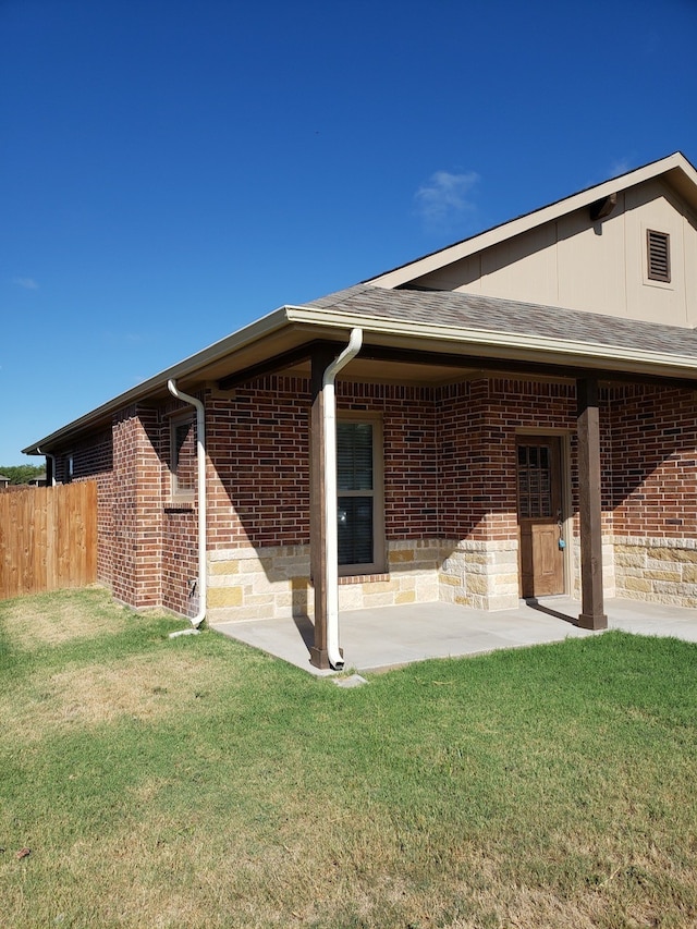 back of property with a lawn and a patio area