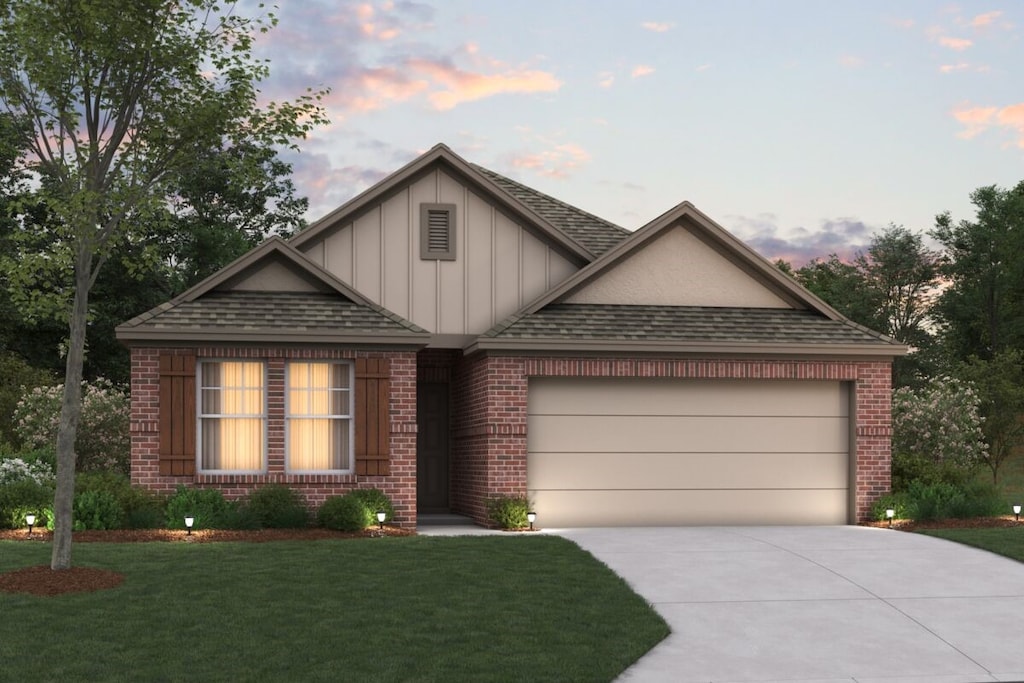 view of front of home with a garage and a yard