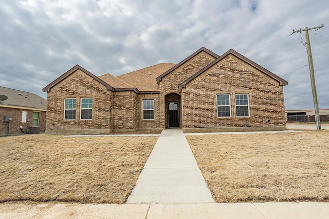 view of front of home featuring a front yard and central air condition unit