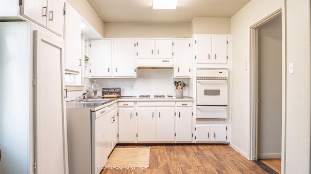 kitchen featuring white cabinetry, sink, light hardwood / wood-style floors, and white appliances