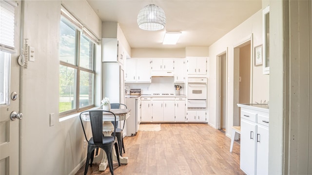 kitchen featuring pendant lighting, white cabinetry, and plenty of natural light