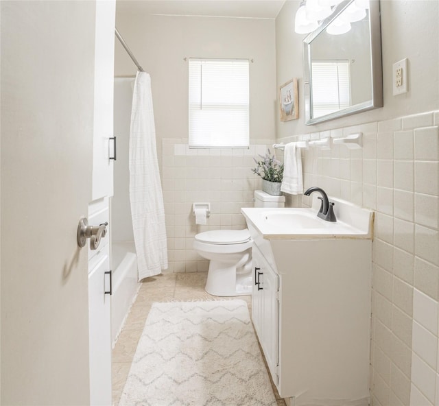 full bathroom featuring vanity, tile patterned flooring, toilet, shower / bathtub combination with curtain, and tile walls