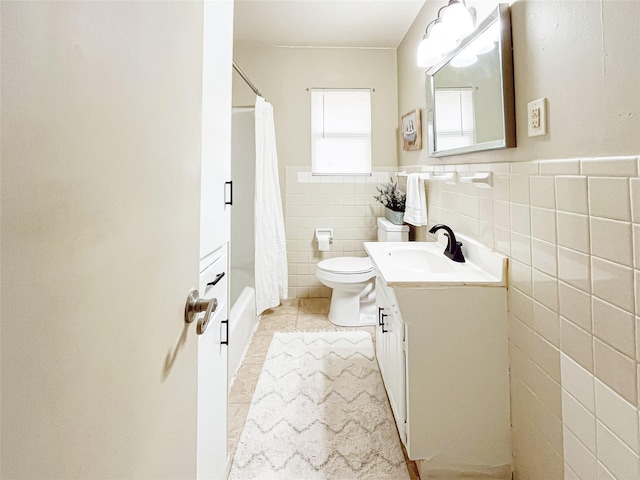 full bathroom featuring vanity, tile patterned floors, shower / bath combination with curtain, toilet, and tile walls