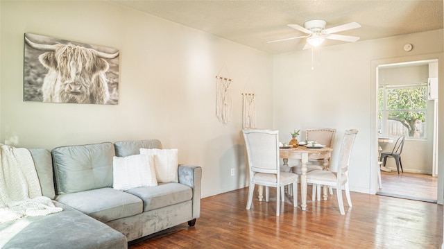 living room with hardwood / wood-style flooring, ceiling fan, and a textured ceiling