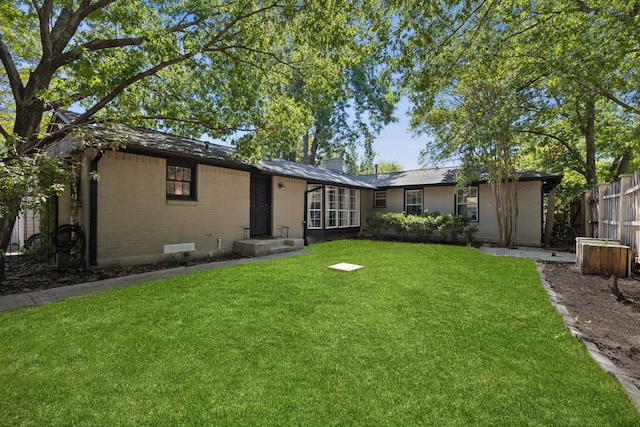 rear view of house featuring a lawn