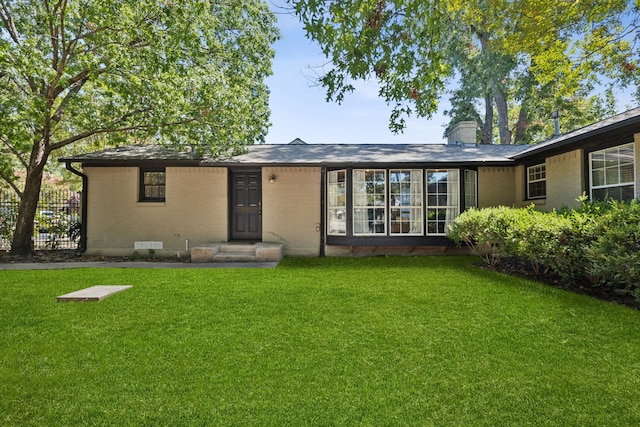 rear view of house featuring a yard