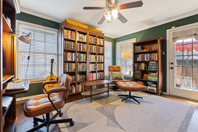 living area with ceiling fan, crown molding, and a healthy amount of sunlight