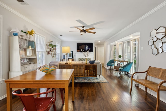 dining space featuring dark wood-style floors, ornamental molding, a wealth of natural light, and a ceiling fan