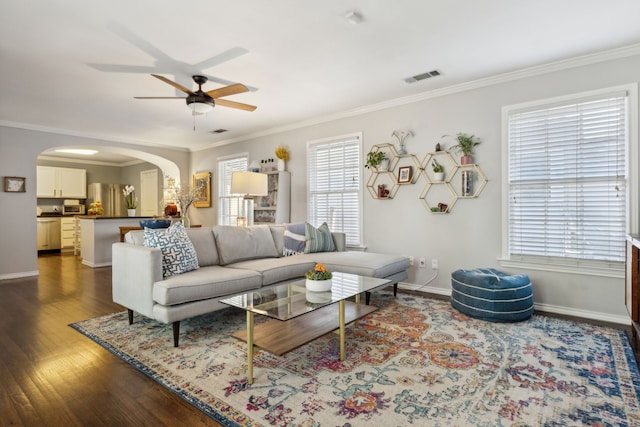 living room with ornamental molding, dark hardwood / wood-style floors, and ceiling fan