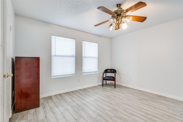 empty room featuring a textured ceiling, light hardwood / wood-style flooring, and ceiling fan