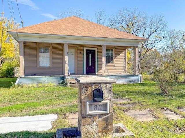 bungalow-style house featuring covered porch and a front lawn